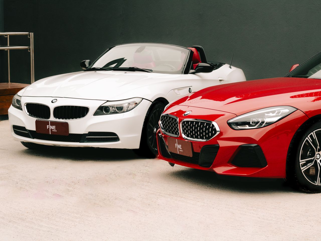 services-02 Dynamic shot of luxury red and white convertible cars displayed outdoors for sale.