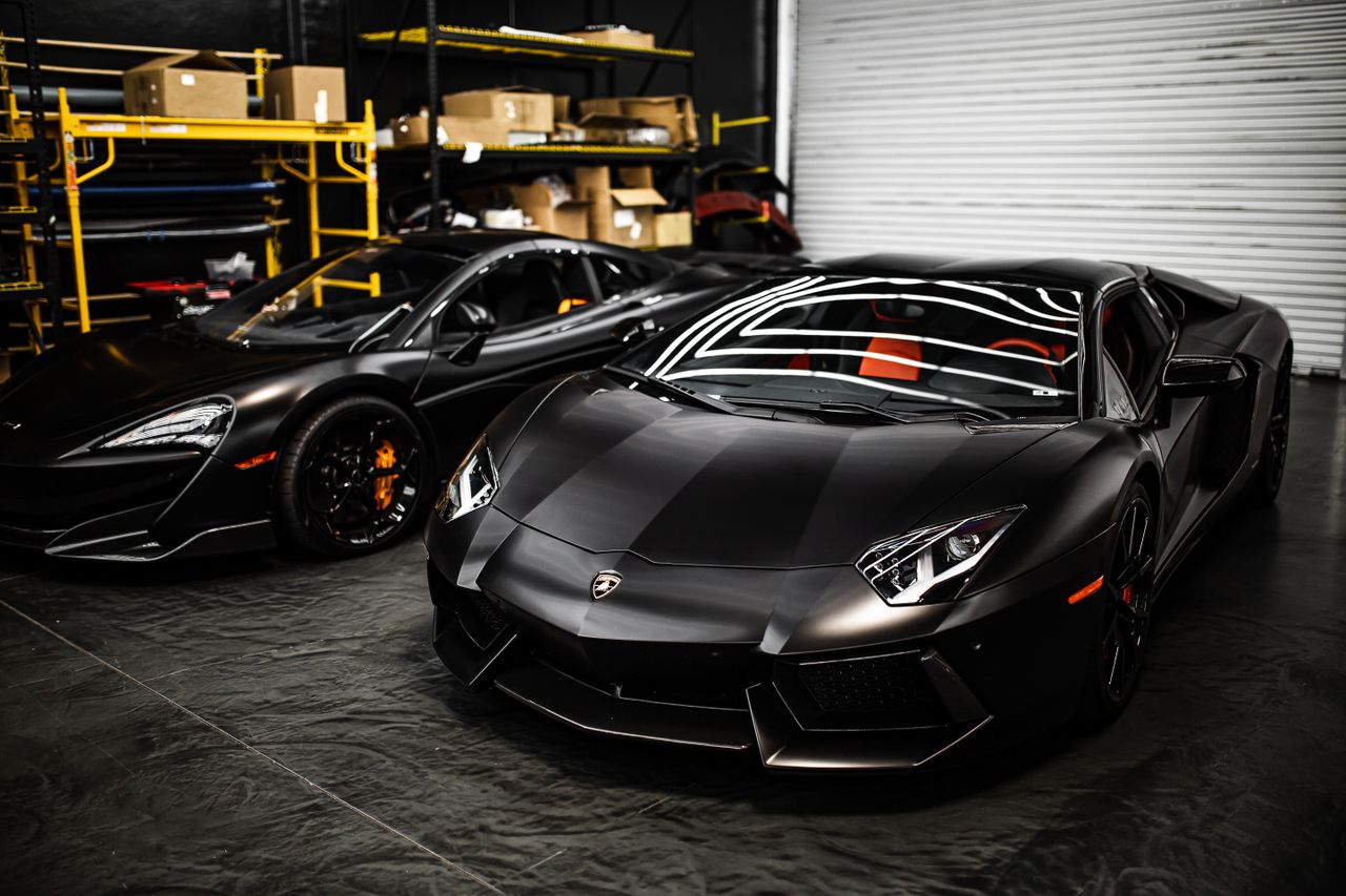 Sleek black sports cars parked in an industrial garage with modern design features.